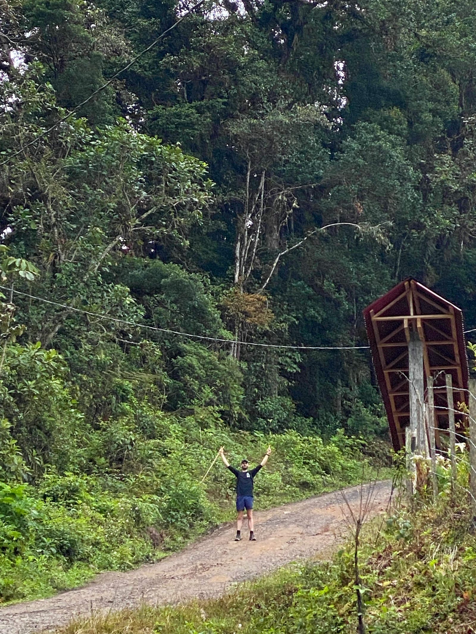Hiker crossing a suspension bridge over a river on El Camino de Costa Rica